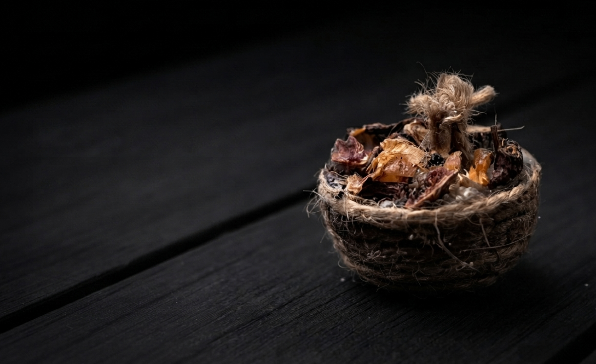 IgnFyr natural wood-and-wax fire starter with jute wick on a dark charcoal background
